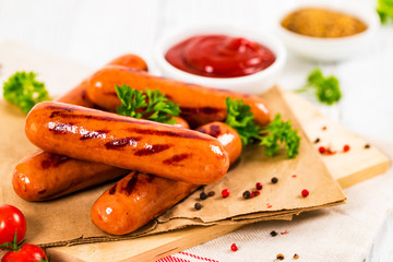 Grilled Smoked Sausages on Wooden Background. Selective focus.
