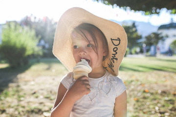 funny girl in wicker hat eats ice cream, close-up