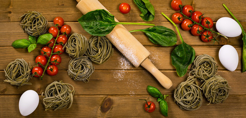 Spinach and Basil Pasta Nests on Wooden Background. Selective focus.