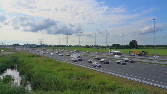 Commuters in cars driving on highway A1 from Amsterdam to the south seen from the front, Muiden, The Netherlands, July 9th 2019