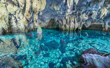 Natural lake inside limestone cave. Colorful reflection, turquoise transparent water, summer...