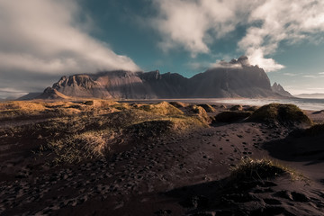 Famous Vestrahorn mountain in Stokksnes, Iceland. Sunrise on beach full of tufts of grass.