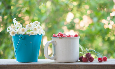 Summer background with garden berries and bouquet of white flowers