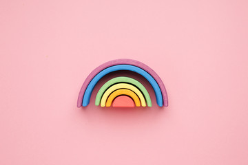 Multicolored lgbt wooden rainbow on pink background