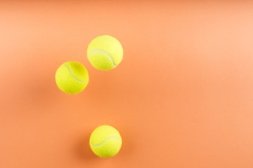 Tennis balls bouncing on orange. Concept