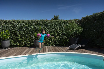 Fille de 7 ans sautant dans la piscine
