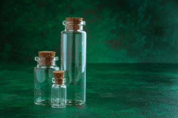 Obraz na płótnie Canvas empty glass test-tubes with bungs at green background
