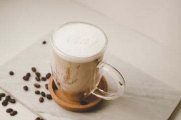 Ice coffee in the glass topped whipping cream with coffee beans. Cold summer drink on wooden...