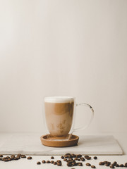 Ice coffee in the glass topped whipping cream with coffee beans. Cold summer drink on wooden background and copy space. Advertising for caramel mocha and chocolate beverage for the cafe.