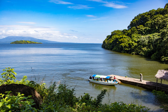 Scenic View of a Small Boat Coming into the Tiny Landing Port at Zapatera Island with Mombacho Volcano in the Distance on Lake Nicaragua