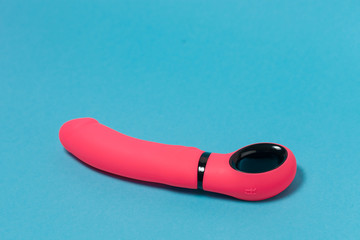 Erotic pleasure toy on a blue background. Sex gadget and masturbation device. A pink rubber and...