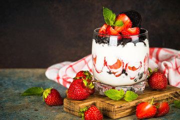 Strawberry dessert parfait with yogurt and chocolate cookies.