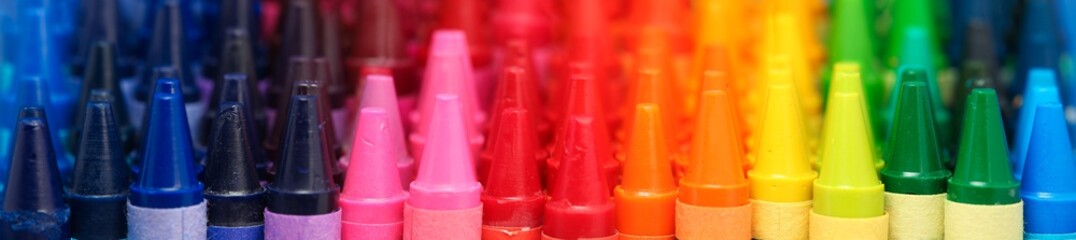 Box of crayons in a rainbow of colors background - obrazy, fototapety, plakaty
