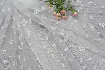 White wooden background with white spring flowers roses and lace ribbon. Happy womans day. The texture of lace on wooden background.