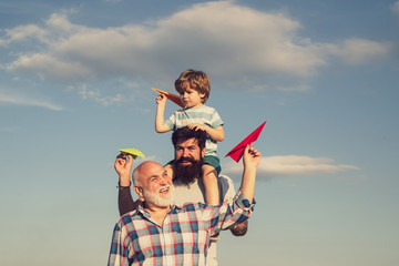 Fathers day - grandfather, father and son are hugging and having fun together. Airplane ready to...