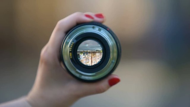 Close-up of womans hand showing camera objective against blurred background
