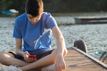 young man with mobile phone at sunset outdoors