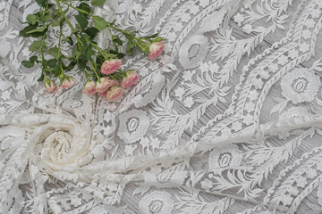 White wooden background with white spring flowers roses and lace ribbon. Happy womans day. The texture of lace on wooden background.