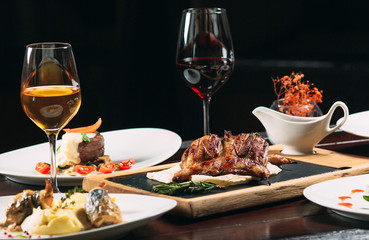 Grilled partridge, sea bass, Tartarus.  Different dishes on the table in the restaurant.