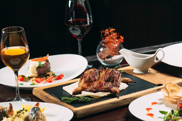 Grilled partridge, sea bass, Tartarus.  Different dishes on the table in the restaurant.
