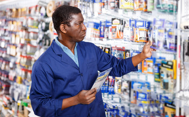 salesman arranging different goods on stand in shop