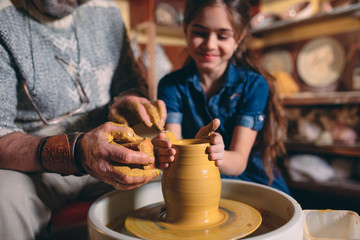 Pottery workshop. Grandpa teaches granddaughter pottery. Clay modeling