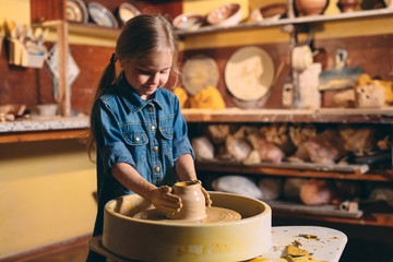 Pottery workshop. A little girl makes a vase of clay. Clay modeling