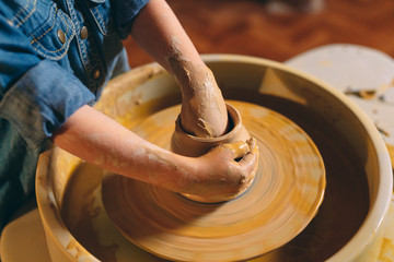 Pottery workshop. A little girl makes a vase of clay. Clay modeling