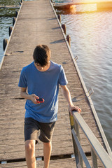 young man with mobile phone at sunset outdoors