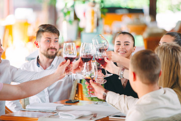 Friends drink wine on the terrace of the restaurant.