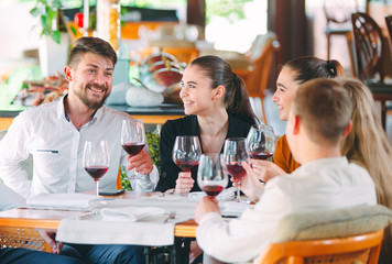 Friends drink wine on the terrace of the restaurant.