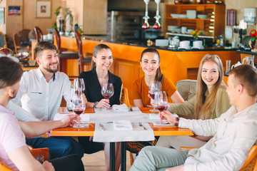 Friends drink wine on the terrace of the restaurant.