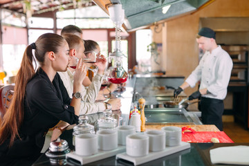 The chef prepares food in front of the visitors in the restaurant