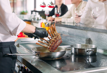 The chef prepares food in front of the visitors in the restaurant