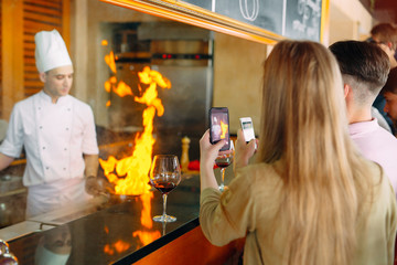 The chef prepares food in front of the visitors in the restaurant