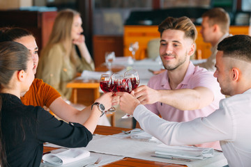 Friends drink wine on the terrace of the restaurant.