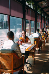 A young couple drinking wine in a restaurant near the window.