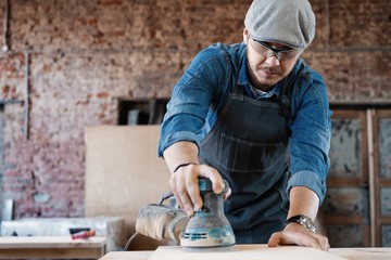 Successful handsome businessman with stylish cap work in carpentry