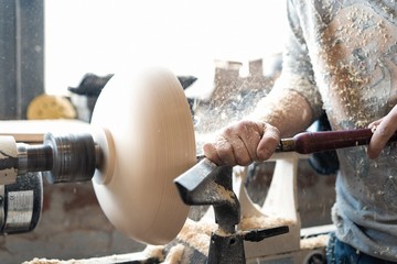 Carpenter working on woodworking machines in carpentry shop. A man works in a carpentry shop.