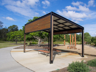 Modern pergola and sitting area with play ground behind in Public Park - obrazy, fototapety, plakaty