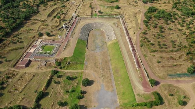 Aerial drone video of unique and well preserved archaeological site and citadel of Ancient Messene featuring massive stadium and theatre, Messinia, Peloponnese, Greece