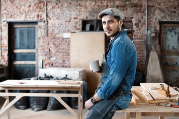 Successful handsome businessman with stylish cap work in carpentry