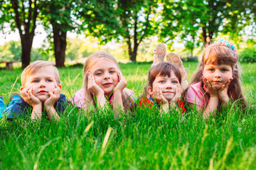 A group of children lying on the green grass in the Park. The interaction of the children.