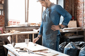 Successful handsome businessman with stylish cap work in carpentry