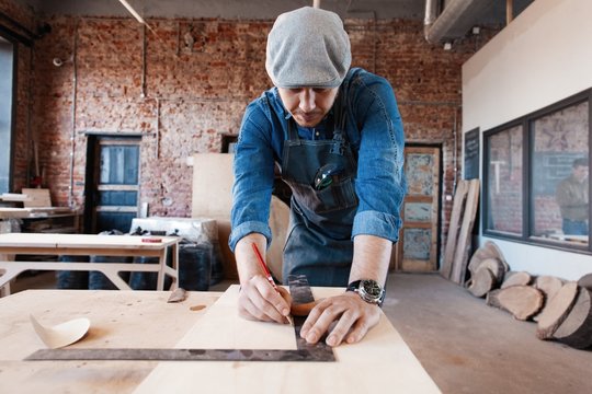 Successful handsome businessman with stylish cap work in carpentry