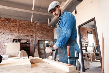 Successful handsome businessman with stylish cap work in carpentry