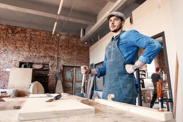 Successful handsome businessman with stylish cap work in carpentry