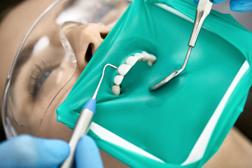 Pretty woman's teeth treatment in dental clinic