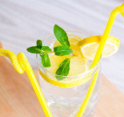 Glasss of mojito with lemon and drinking straw