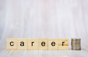 Wooden cube block with word career and coins on the stack. Business career planning growth to success concept